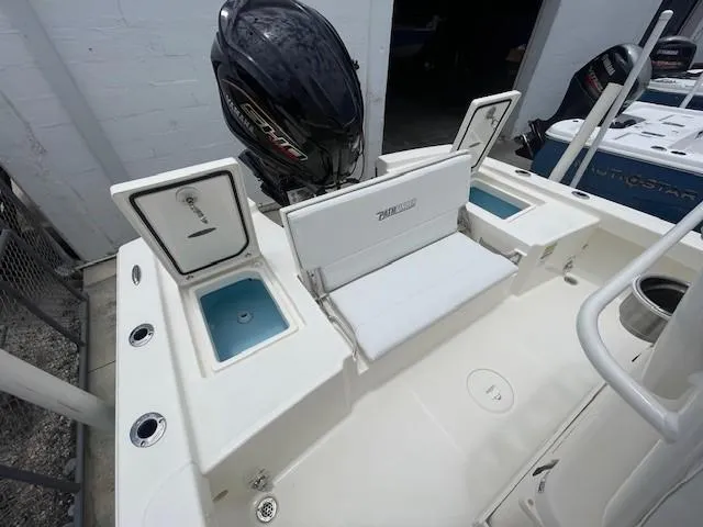 Slide: The Image of 2025 Pathfinder 2200 TRS boat with open storage compartments and outboard motor. - 11