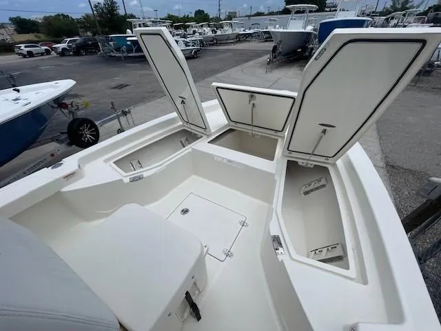 Slide: The Image of 2025 Pathfinder 2200 TRS boat with open storage compartments in a marina setting. - 13