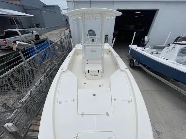 Slide: The Image of 2025 Pathfinder 2200 TRS boat, white deck, parked outdoors near other boats. - 14