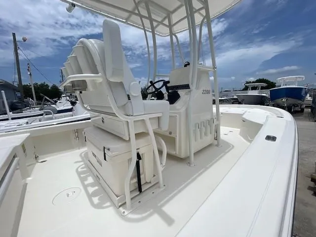 Slide: The Image of 2025 Pathfinder 2200 TRS boat interior with seating and steering console under a clear sky. - 3