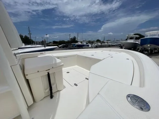Slide: The Image of 2025 Pathfinder 2200 TRS boat interior with seating and storage, under a partly cloudy sky. - 4