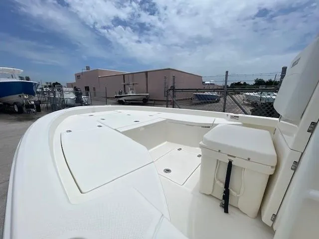 Slide: The Image of 2025 Pathfinder 2200 TRS boat deck with storage compartments, docked under a cloudy sky. - 5