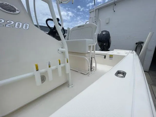 Slide: The Image of 2025 Pathfinder 2200 TRS boat interior with seating and steering console under a blue sky. - 6