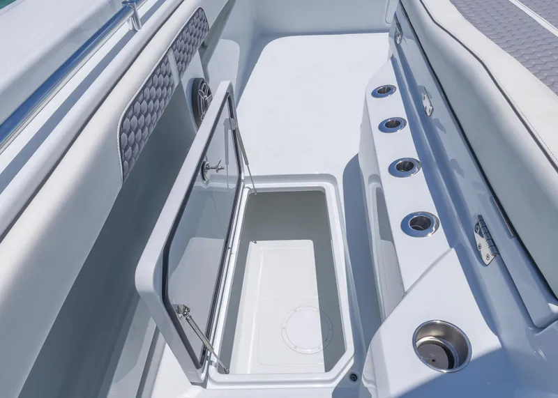 Slide: The Image of 2026 Invincible 38 Catamaran interior with open storage compartment and cup holders. - 15