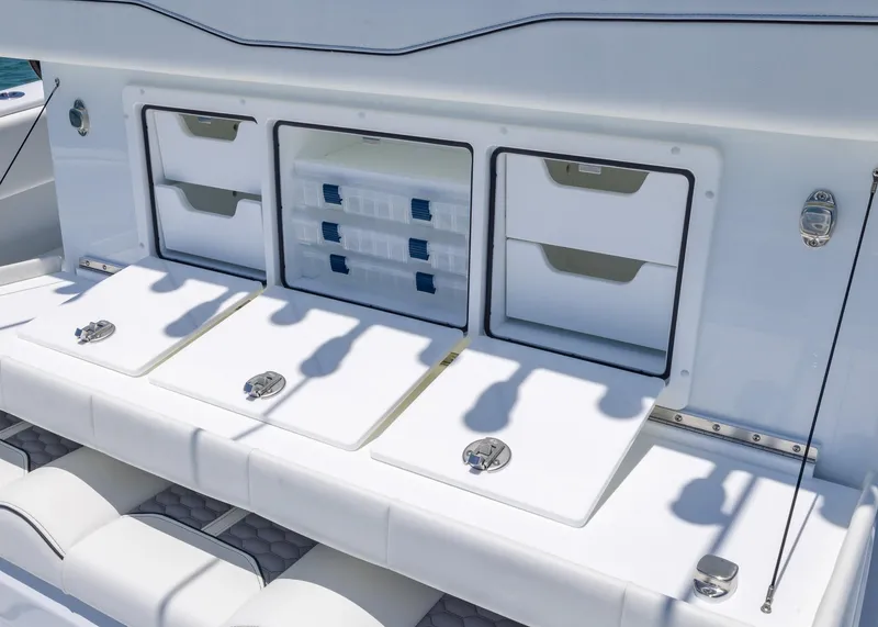 Slide: The Image of 2026 Invincible 38 Catamaran storage compartments with organized tackle boxes and drawers. - 33