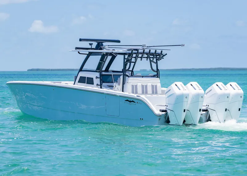 Slide: The Image of 2026 Invincible 38 Catamaran cruising on turquoise waters with triple outboard engines. - 48