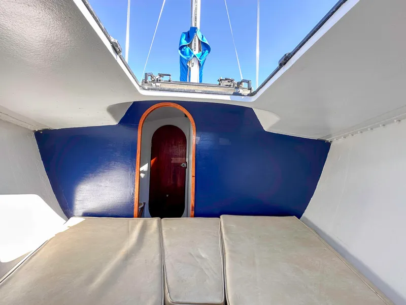 Slide: The Image of Interior of 1983 Racing Sloop sailboat with blue walls and cushioned seating. - 12