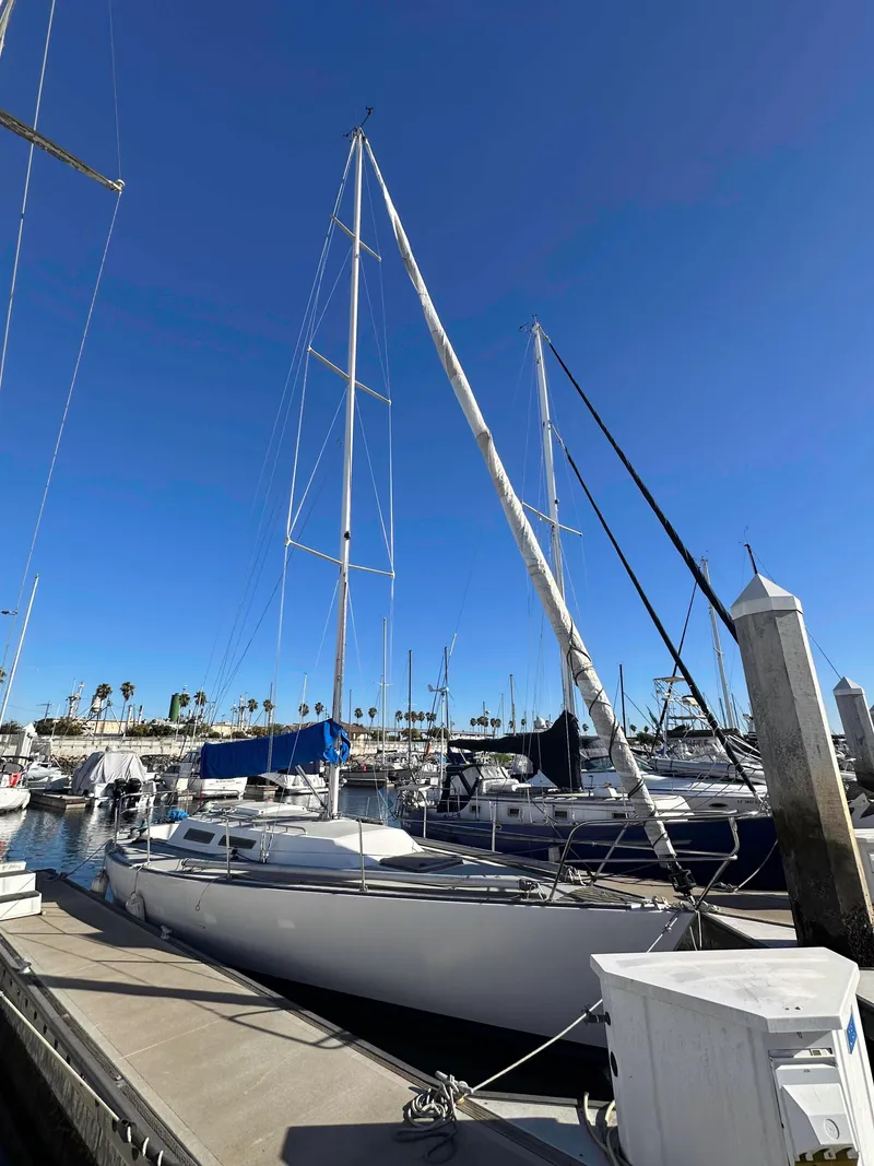 Slide: The Image of 1983 Racing Sloop sailboat docked at marina under clear blue sky. - 3