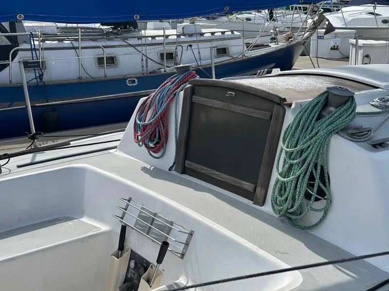 Slide: The Image of 1983 Racing Sloop sailboat deck with coiled ropes and marina background. - 4