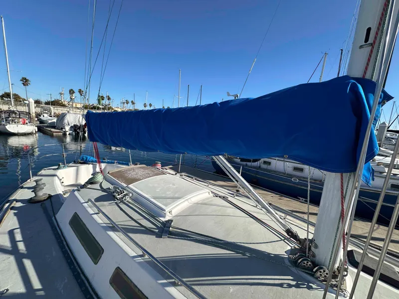 Slide: The Image of 1983 Racing Sloop sailboat docked in marina with blue sail cover. - 5
