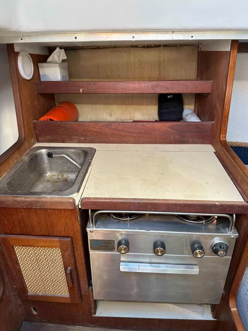 Slide: The Image of Compact kitchen area in a 1983 Racing Sloop sailboat with stove and sink. - 8