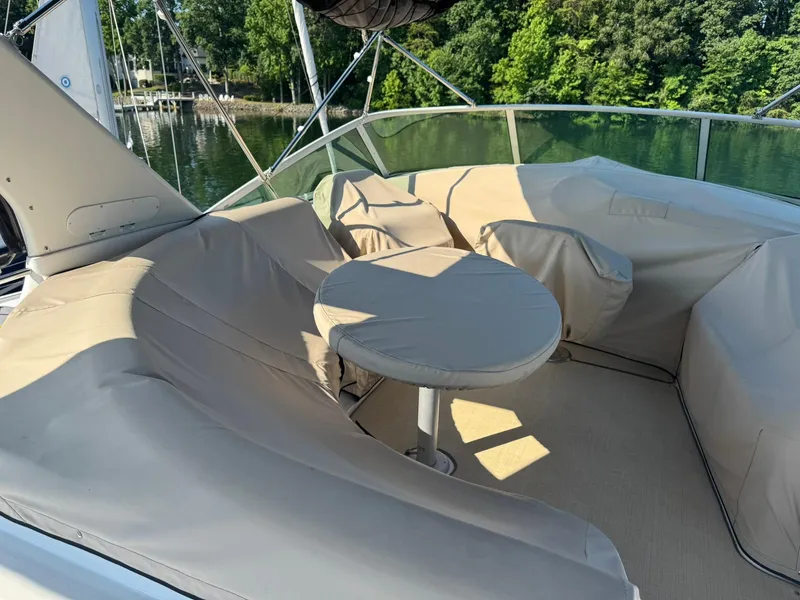 Slide: The Image of 2001 Carver 450 Voyager Pilothouse with covered seating area and table on deck. - 12