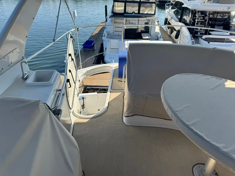 Slide: The Image of 2001 Carver 450 Voyager Pilothouse yacht deck with covered seating and dock view. - 15