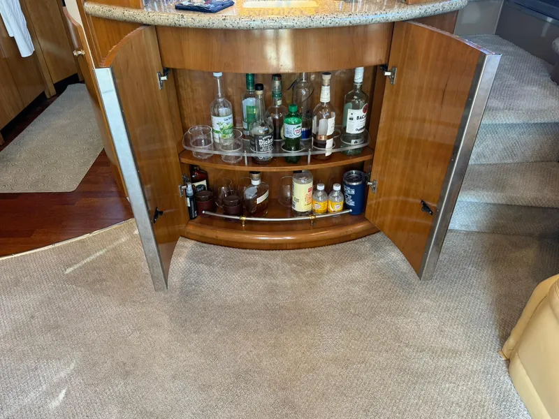 Slide: The Image of Open cabinet with liquor bottles and glasses on a 2001 Carver 450 Voyager Pilothouse yacht. - 24