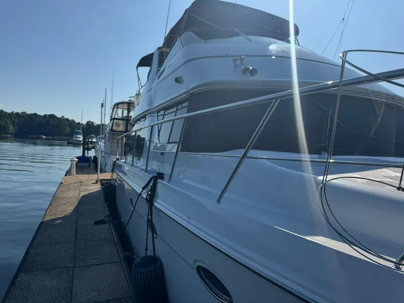 Slide: The Image of 2001 Carver 450 Voyager Pilothouse yacht docked on a sunny day. - 4