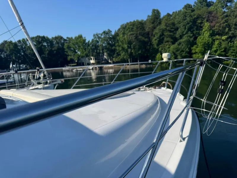 Slide: The Image of 2001 Carver 450 Voyager Pilothouse yacht on a serene lake with lush greenery. - 7