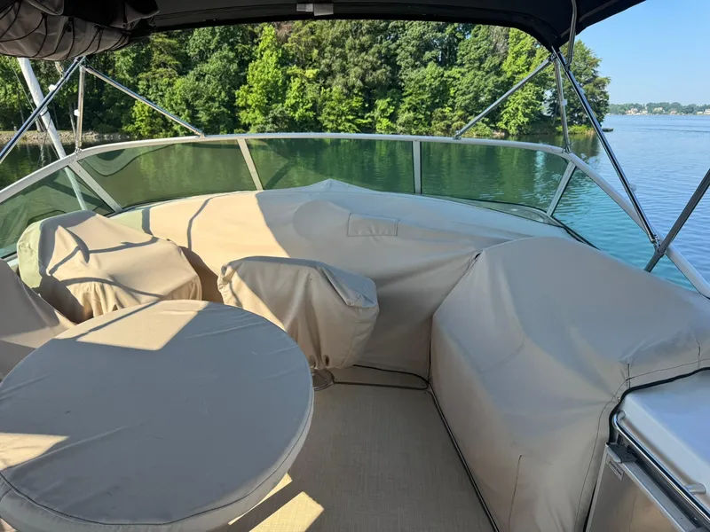 Slide: The Image of 2001 Carver 450 Voyager Pilothouse deck with covered seating, surrounded by water and trees. - 11