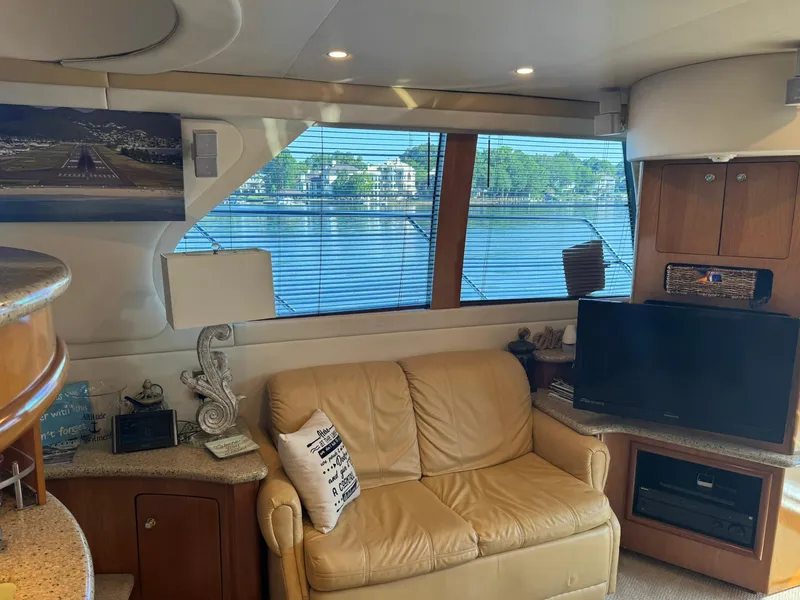 Slide: The Image of Interior of 2001 Carver 450 Voyager Pilothouse with leather sofa, TV, and scenic window view. - 23