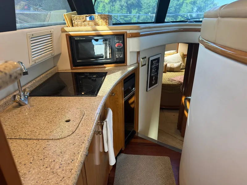 Slide: The Image of 2001 Carver 450 Voyager Pilothouse kitchen with stove, microwave, and cozy cabin view. - 32