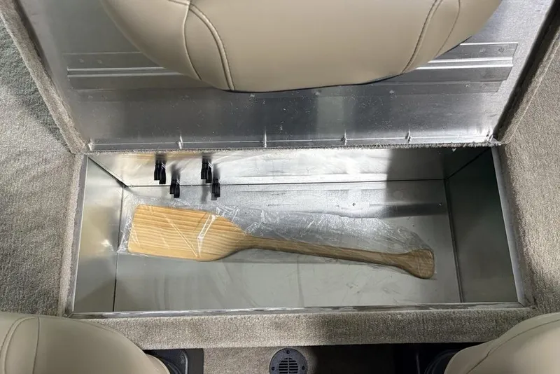 Slide: The Image of Storage compartment in 2026 Tracker Bass Tracker® Classic Limited boat with wooden paddle. - 22