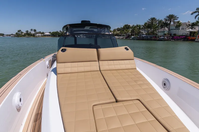 Slide: The Image of 2025 Pardo Yachts 38 with tan sunbed, cruising on a serene waterway. - 20