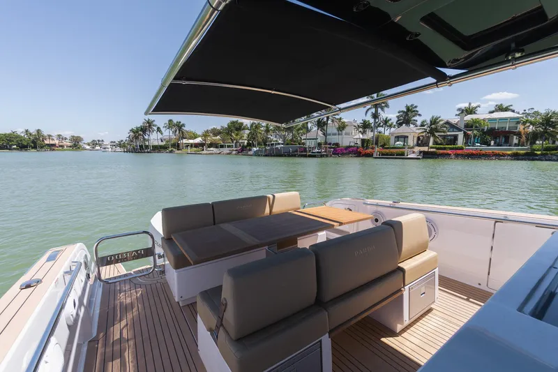Slide: The Image of 2025 Pardo Yachts 38 with elegant seating, shaded deck, and scenic waterfront view. - 29