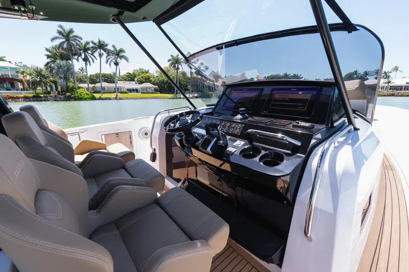 Slide: The Image of 2025 Pardo Yachts 38 cockpit with modern controls and luxurious seating by a scenic waterfront. - 21