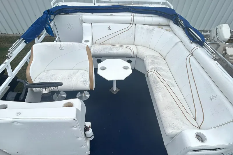 Slide: The Image of 1996 JC Suntoon 24 boat interior with steering wheel and seating. - 10