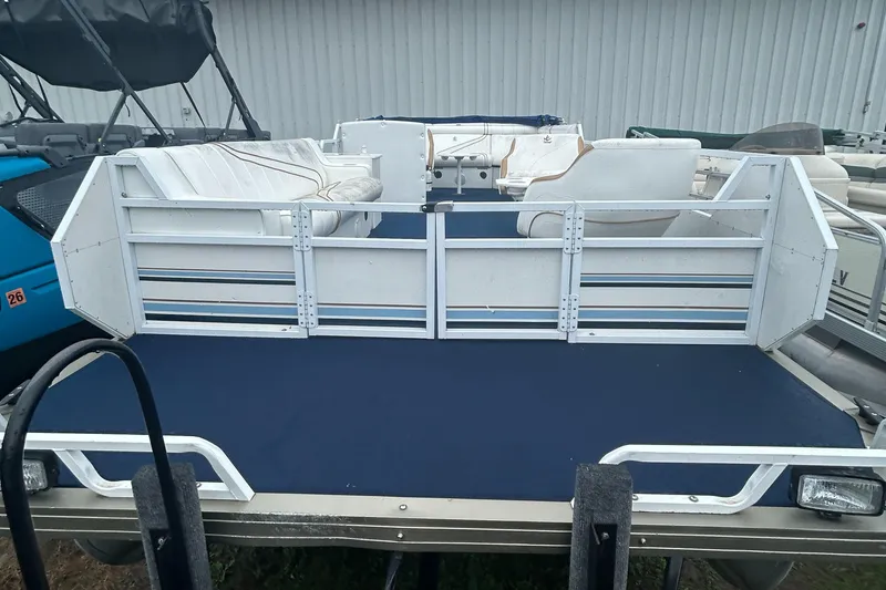 Slide: The Image of 1996 JC Suntoon 24 pontoon boat interior with white seating and blue flooring. - 7