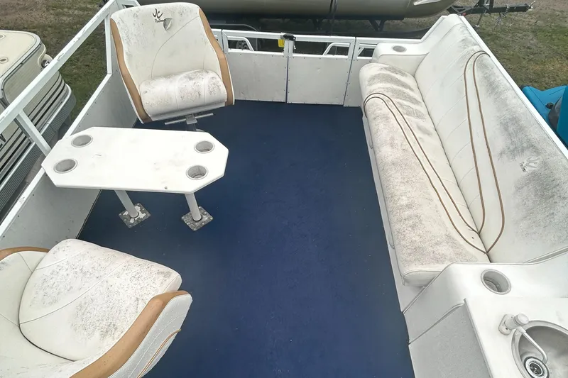 Slide: The Image of Interior of a 1996 JC Suntoon 24 boat with white seating and blue carpet. - 9