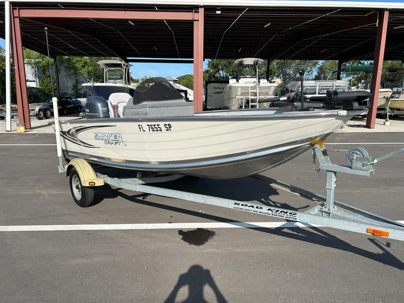 The Image of 2020 Smoker Craft Angler 16 XL SC boat on trailer with canopy in parking lot. - 1