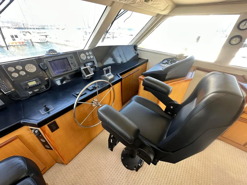 Slide: The Image of Captain's chair and control panel in 2000 Viking Enclosed Flybridge yacht cockpit. - 13