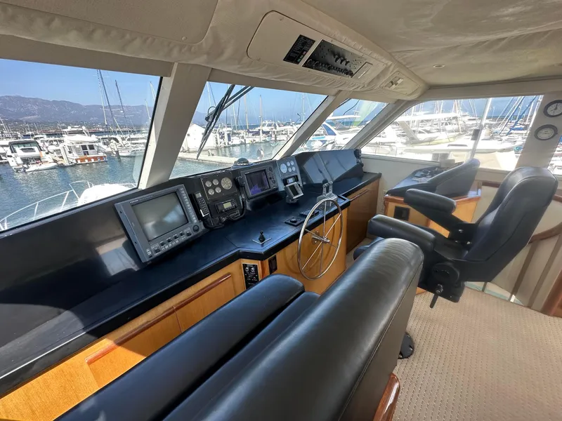 Slide: The Image of Interior of 2000 Viking Enclosed Flybridge yacht with navigation equipment and leather seating. - 15