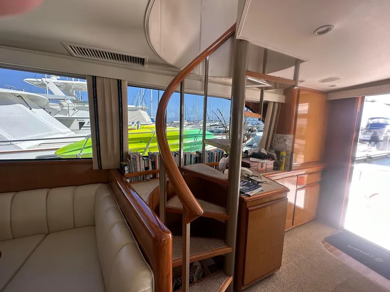 Slide: The Image of Interior of 2000 Viking Enclosed Flybridge yacht with spiral staircase and marina view. - 20