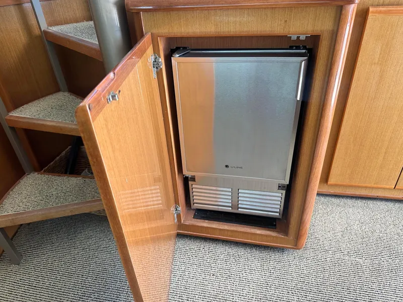 Slide: The Image of Small refrigerator inside a wooden cabinet on a 2000 Viking Enclosed Flybridge yacht. - 23