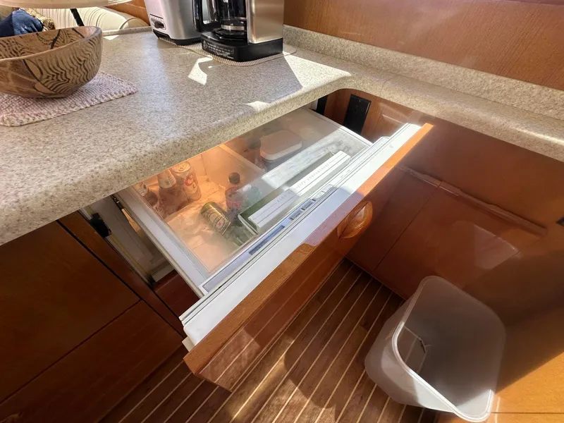 Slide: The Image of Kitchen area of 2000 Viking Enclosed Flybridge with open drawer fridge. - 25
