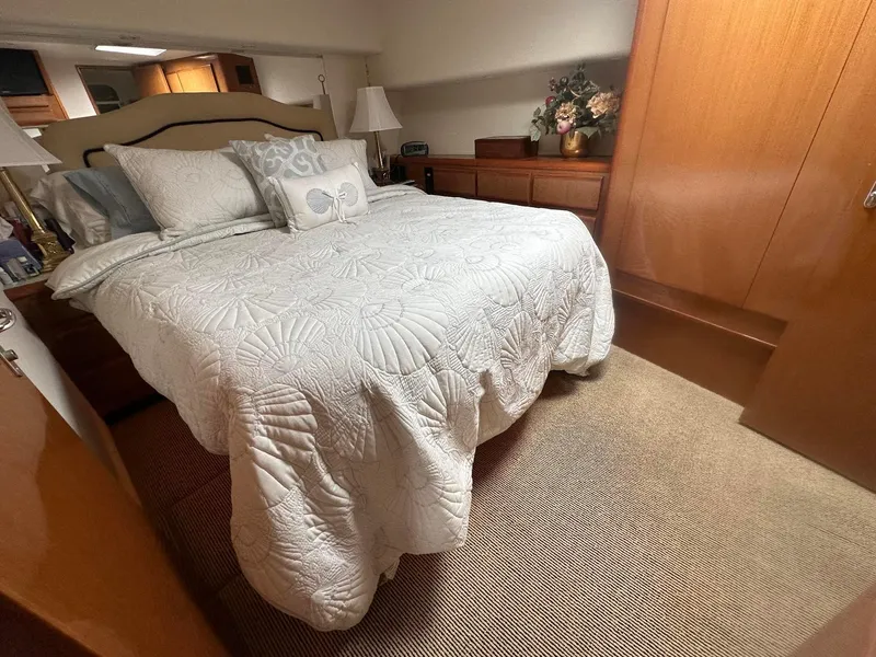 Slide: The Image of Luxurious bedroom interior of 2000 Viking Enclosed Flybridge yacht with elegant bedding. - 27