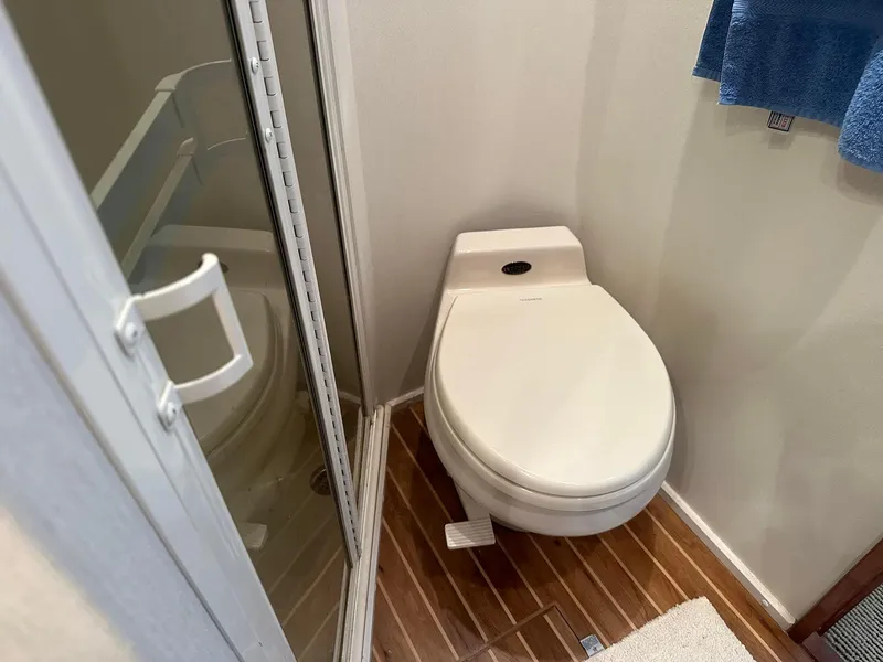Slide: The Image of Toilet in 2000 Viking Enclosed Flybridge yacht bathroom with wooden flooring. - 46