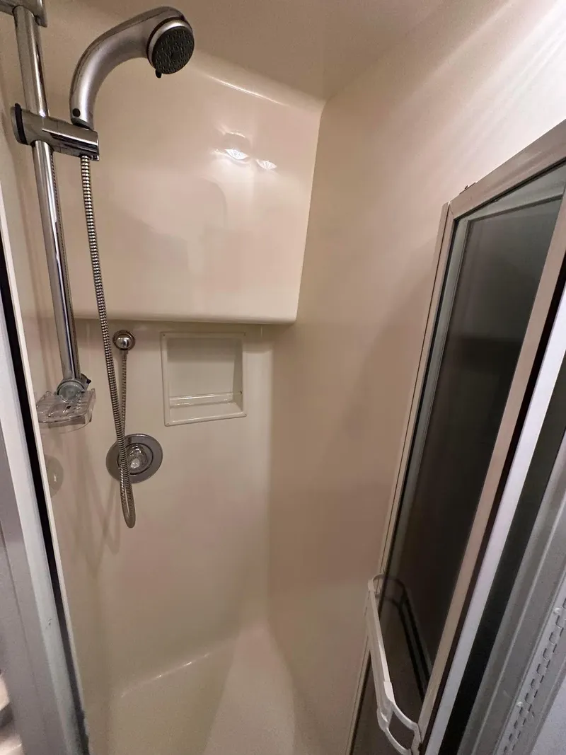 Slide: The Image of Shower area in 2000 Viking Enclosed Flybridge yacht, featuring handheld showerhead and glass door. - 48