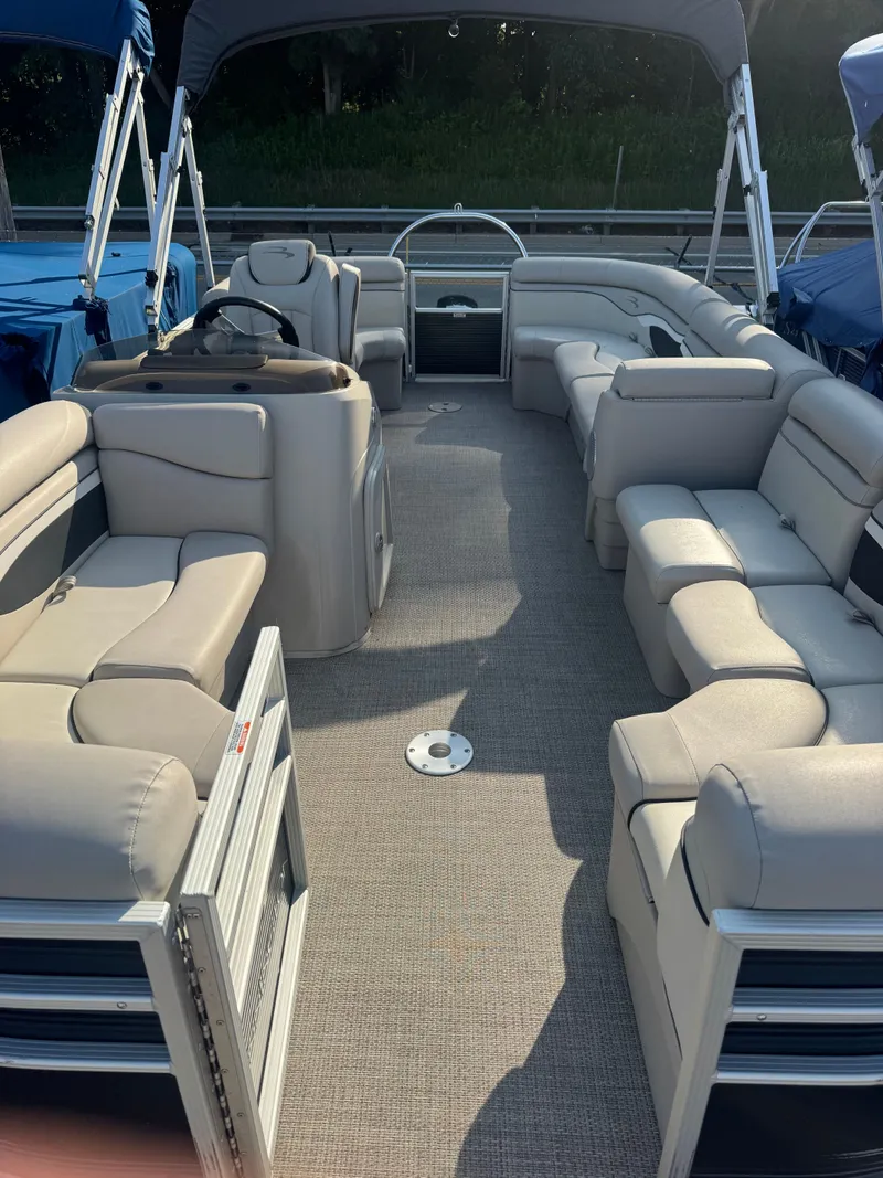Slide: The Image of The image shows the interior of a 2019 Bennington 20SSRCX pontoon boat with beige seating. - 5