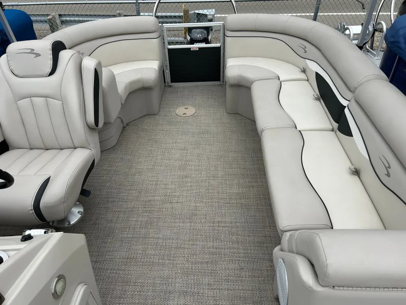 Slide: The Image of Interior of a Bennington 20SSRCX pontoon boat with beige upholstered seating and carpeted floor. - 6