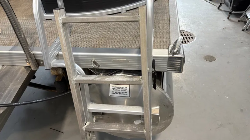 Slide: The Image of An aluminum ladder is attached to a pontoon boat, which is on a concrete floor. - 17