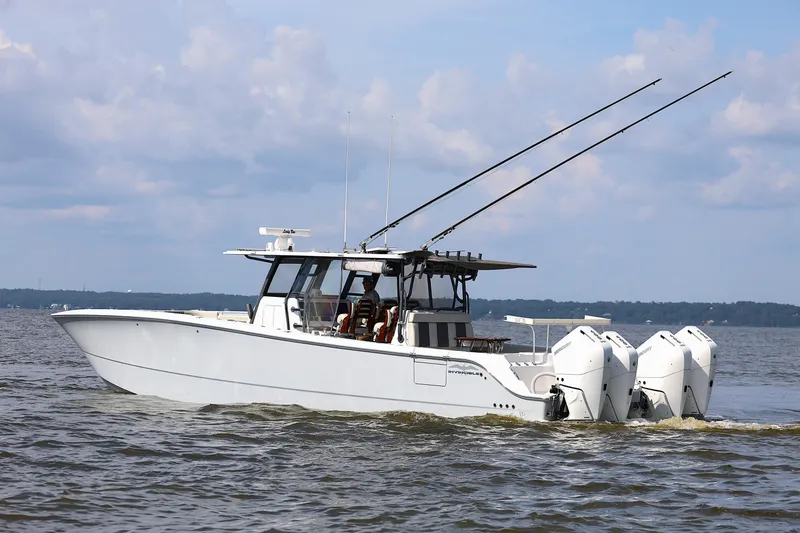 Slide: The Image of 2022 Invincible 46 Catamaran cruising on open water under a cloudy sky. - 15