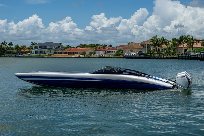 The Image of 2023 Performance Powerboats P360 cruising on a scenic waterfront with luxury homes. - 0
