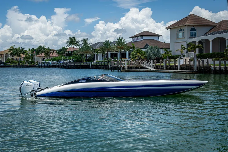 Slide: The Image of 2023 Performance Powerboats P360 cruising on a scenic waterfront with luxury homes. - 13