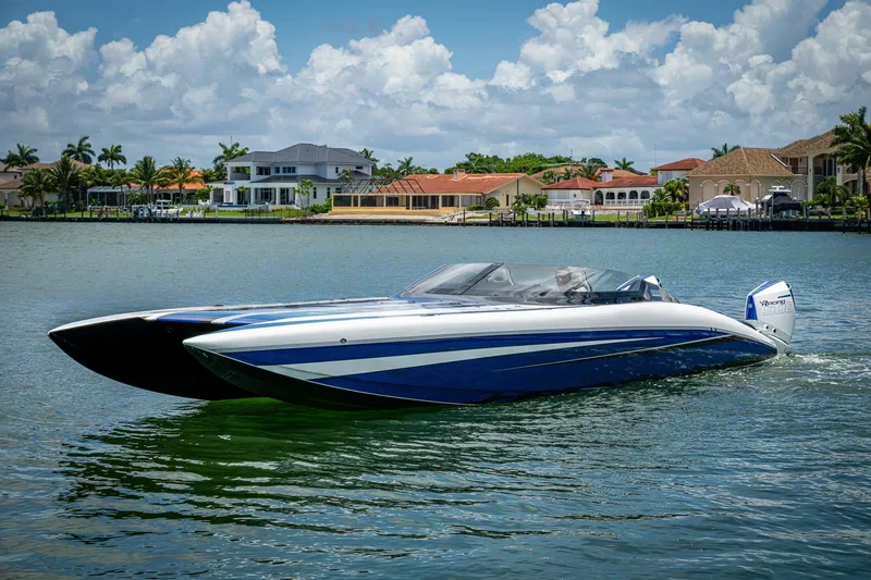 Slide: The Image of 2023 Performance Powerboats P360 cruising on a scenic waterfront with luxury homes. - 5