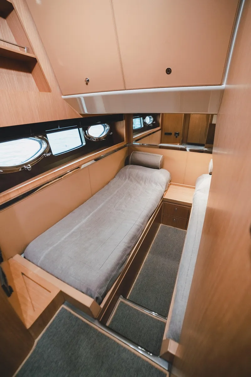Slide: The Image of 2011 Riva SportRiva 56 yacht cabin with single bed, wooden interior, and porthole windows. - 40