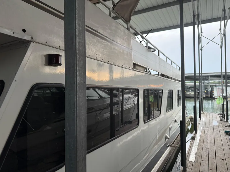 Slide: The Image of 2001 Myacht M Yacht docked in a marina, side view with windows and railing. - 12