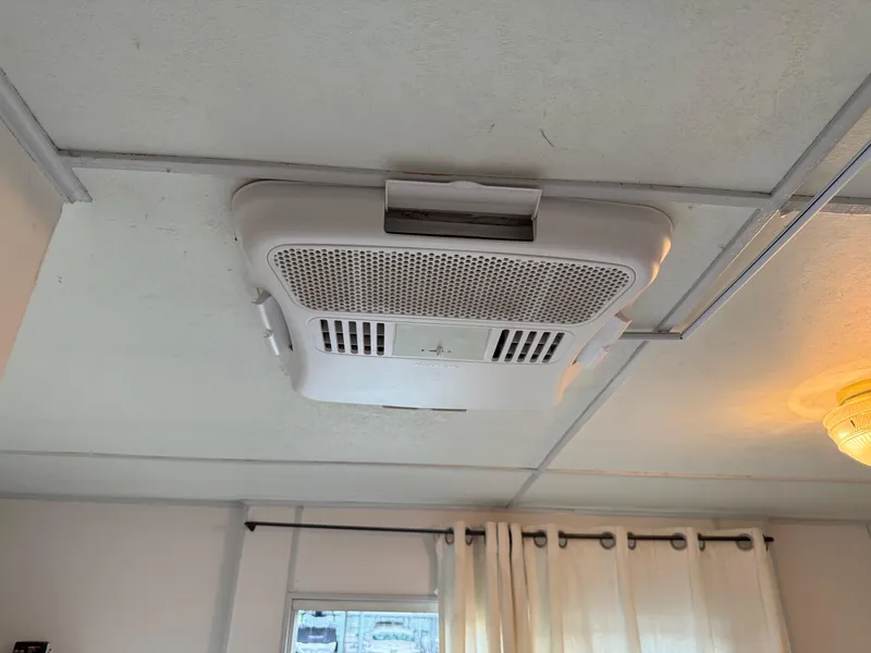 Slide: The Image of Ceiling air conditioning unit inside a 2001 Myacht M Yacht, with curtains and light fixture. - 38