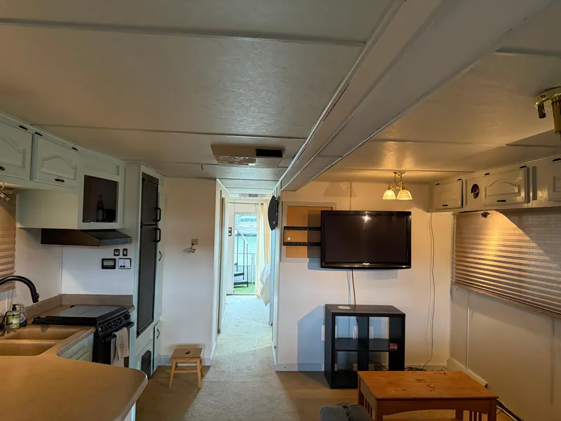 Slide: The Image of Interior of a 2001 Myacht M Yacht featuring a cozy living area with TV and kitchen. - 43